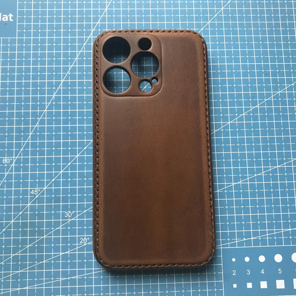 Brown phone case on a blue cutting mat
