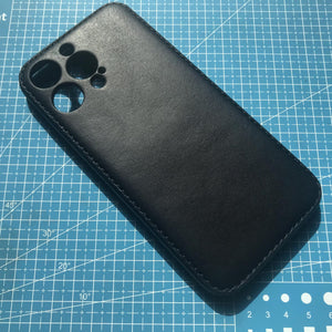 Black phone case on a blue cutting mat